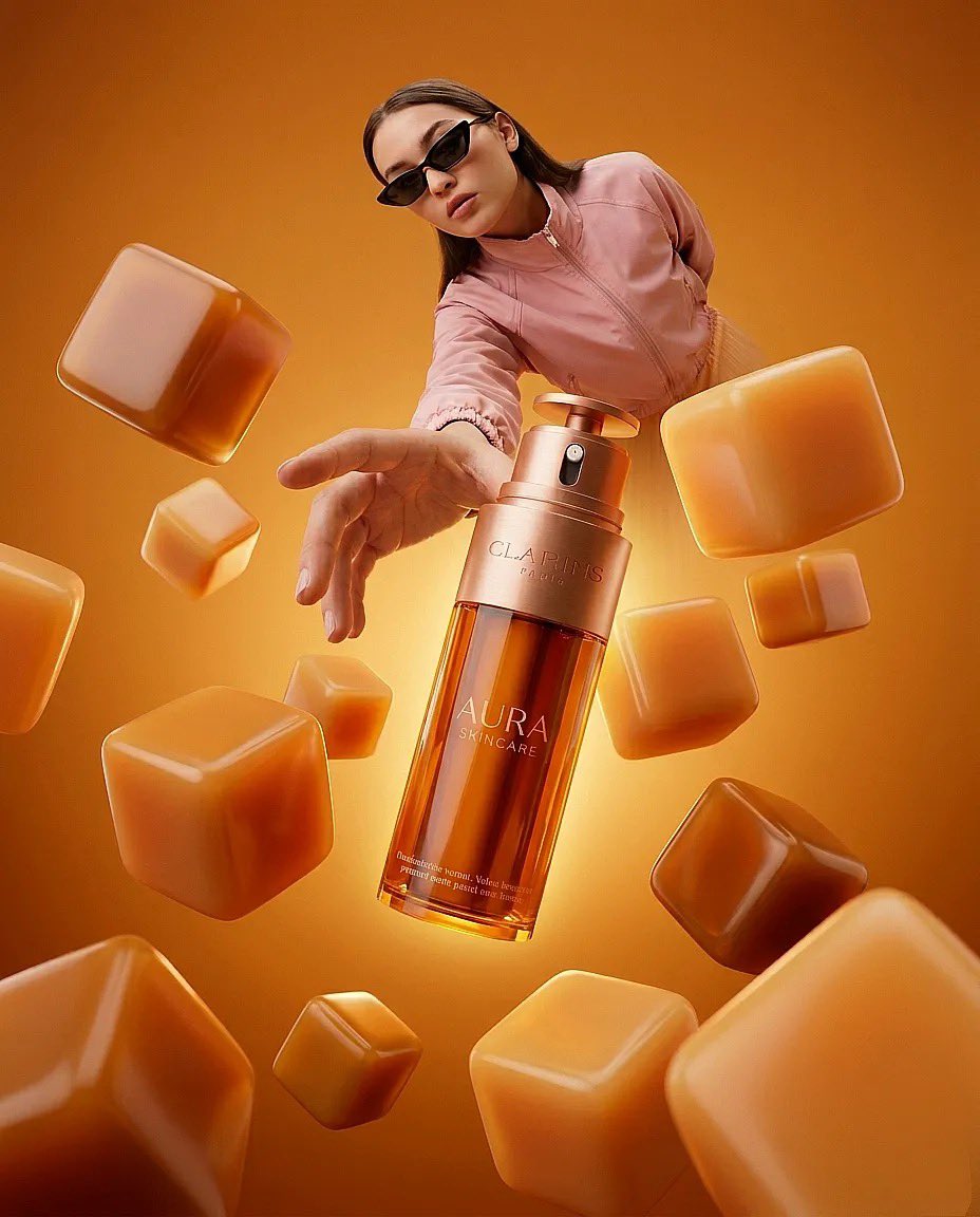 “超现实时尚产品摄影：一只巨大的琥珀色护肤品瓶（Clarins Aura）放置在一个极简盒子房间内的橙白格子地板上，温暖的纯橙色灯光，一位时尚女性戴着太阳镜、穿着桃色夹克伸手去够那只瓶子，广角...