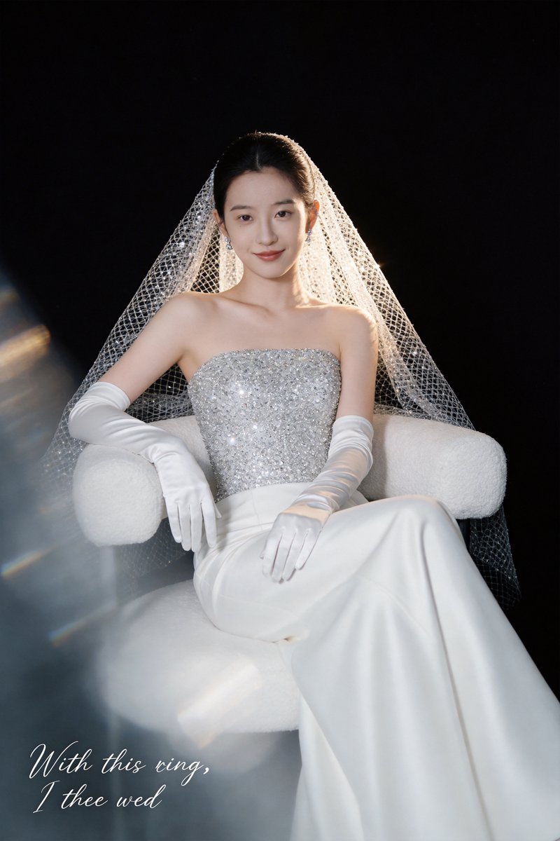 高级婚纱摄影，3:4竖幅，共5张。 人物 新娘冷白皮，身着高定抹胸婚纱，上半身满铺施华洛世奇水晶，弱光下折射细碎星芒；高支数缎面裙摆垂坠柔光兼具。10米手工钉珠头纱，银白水晶颗粒形成通透网纱肌...