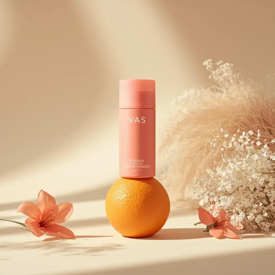 极简高端产品摄影：亮粉色圆柱形护肤瓶，标签为“PAPAYA ENZYME POWDER”（品牌“VAS”），垂直立在一颗新鲜橙子上，居中构图，柔和米色渐变背景，干净的布光场景。左侧摆放精致粉色...