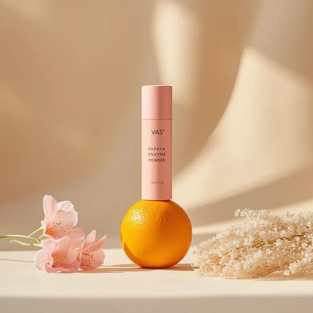 极简高端产品摄影：亮粉色圆柱形护肤瓶，标签为“PAPAYA ENZYME POWDER”（品牌“VAS”），垂直立在一颗新鲜橙子上，居中构图，柔和米色渐变背景，干净的布光场景。左侧摆放精致粉色...