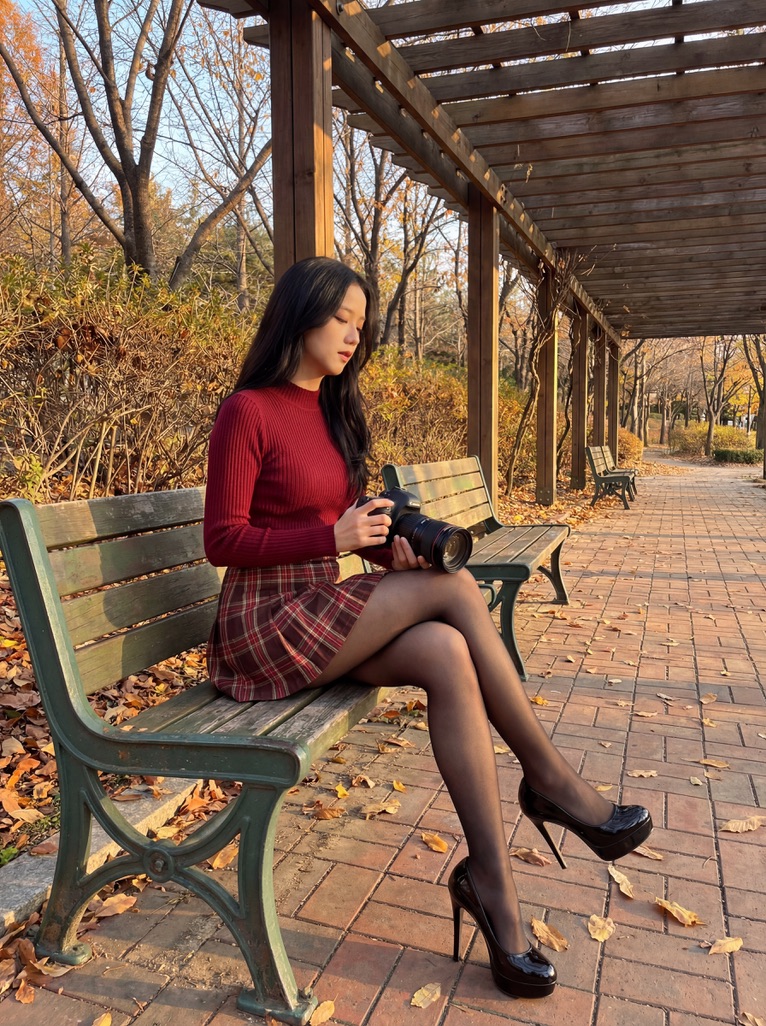{ "prompt": "KPOP偶像Blackpink的Jennie坐在公园绿色长凳上，手持DSLR相机。身穿蓝色制服高领上衣、蓝色格纹迷你裙、透明黑色连裤袜和黑色厚底细高跟鞋。双腿交叉。砖...