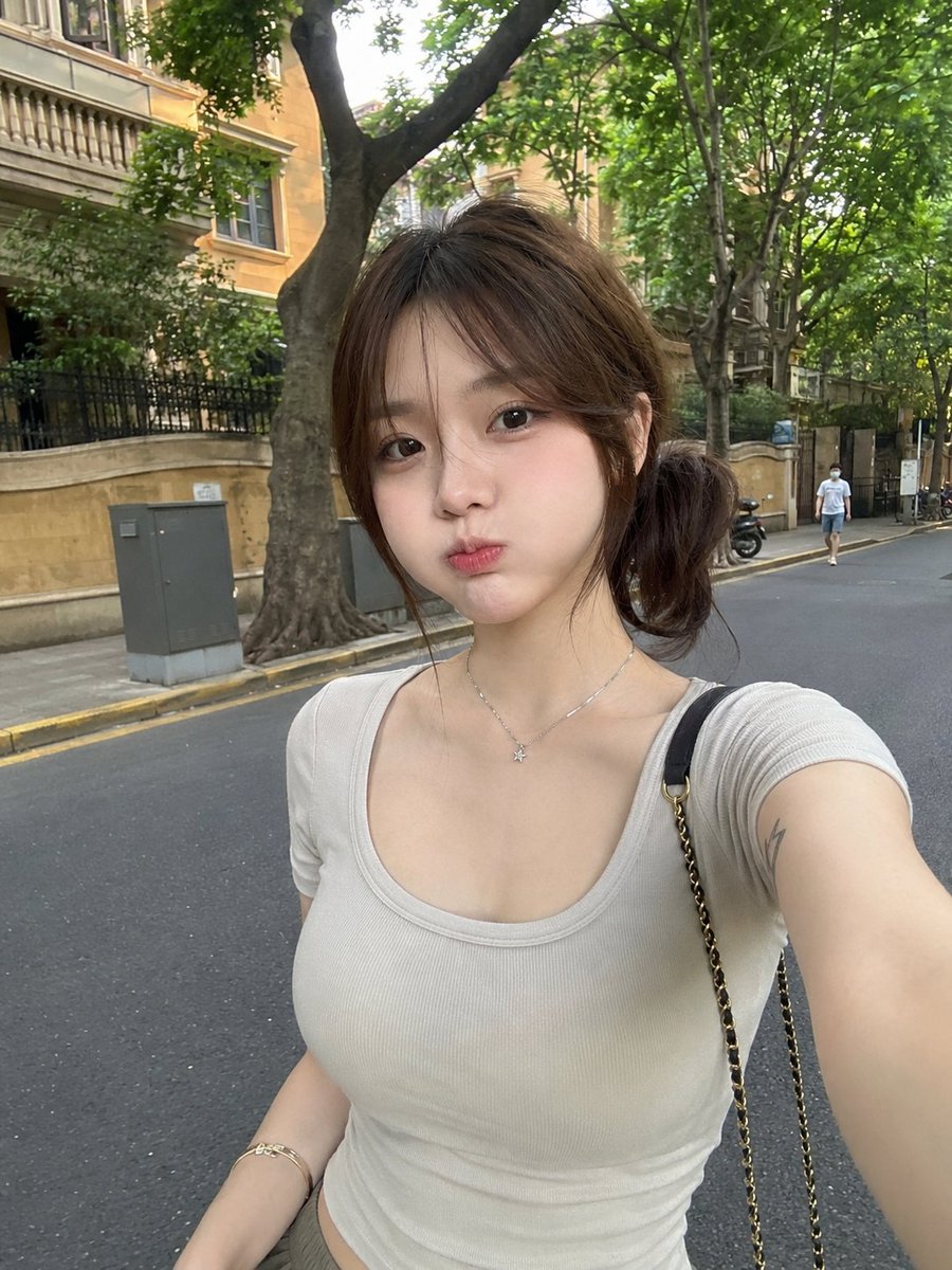 GPT image 2 via higgsfield Prompt 一张RAW、超写实的智能手机照片：一位美丽的年轻东亚女性，白天随意地站在一条安静的绿树成荫的城市街道上。她拥有白皙的瓷器肌肤...