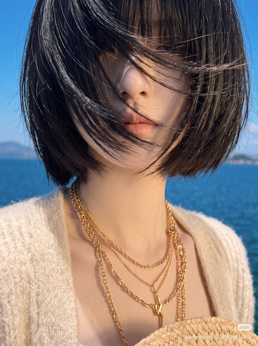 东亚年轻女性审美生活方式肖像，齐刘海黑色短发波波头，强烈的海风戏剧性地将所有头发吹过面部完全遮住眼睛，营造神秘的无脸美学，嘴唇和鼻子透过被风吹起的发丝若隐若现，身穿超大柔软米色针织开衫内搭精致...
