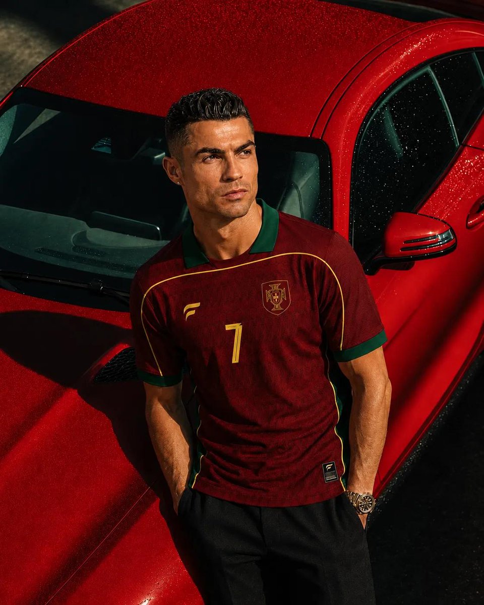 超写实奢华运动时尚大片，主角为克里斯蒂亚诺·罗纳尔多（Cristiano Ronaldo），保留其标志性的面部特征、运动体型、利落发型与自信气质。他身穿一件高级复古葡萄牙足球队球衣，深酒红色配...