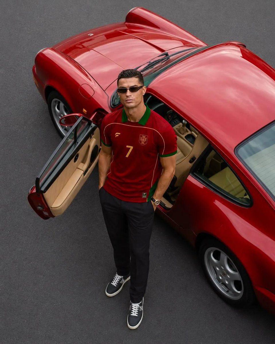 超写实奢华运动时尚大片，主角为克里斯蒂亚诺·罗纳尔多（Cristiano Ronaldo），保留其标志性的面部特征、运动体型、利落发型与自信气质。他身穿一件高级复古葡萄牙足球队球衣，深酒红色配...