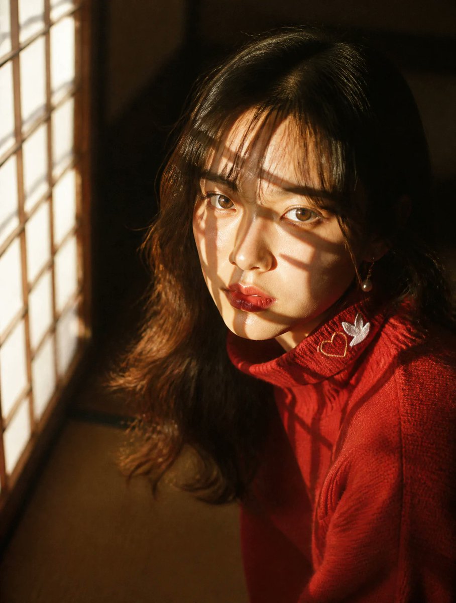 亲密的特写肖像：一位年轻的日本女性跪坐在纸糊障子门旁，傍晚金色的阳光透过障子的木格栅切割而入，在她的脸庞与发丝上投下锐利的几何网格阴影——比百叶窗更具戏剧性与棱角感。深情的、直视镜头的目光。暖...