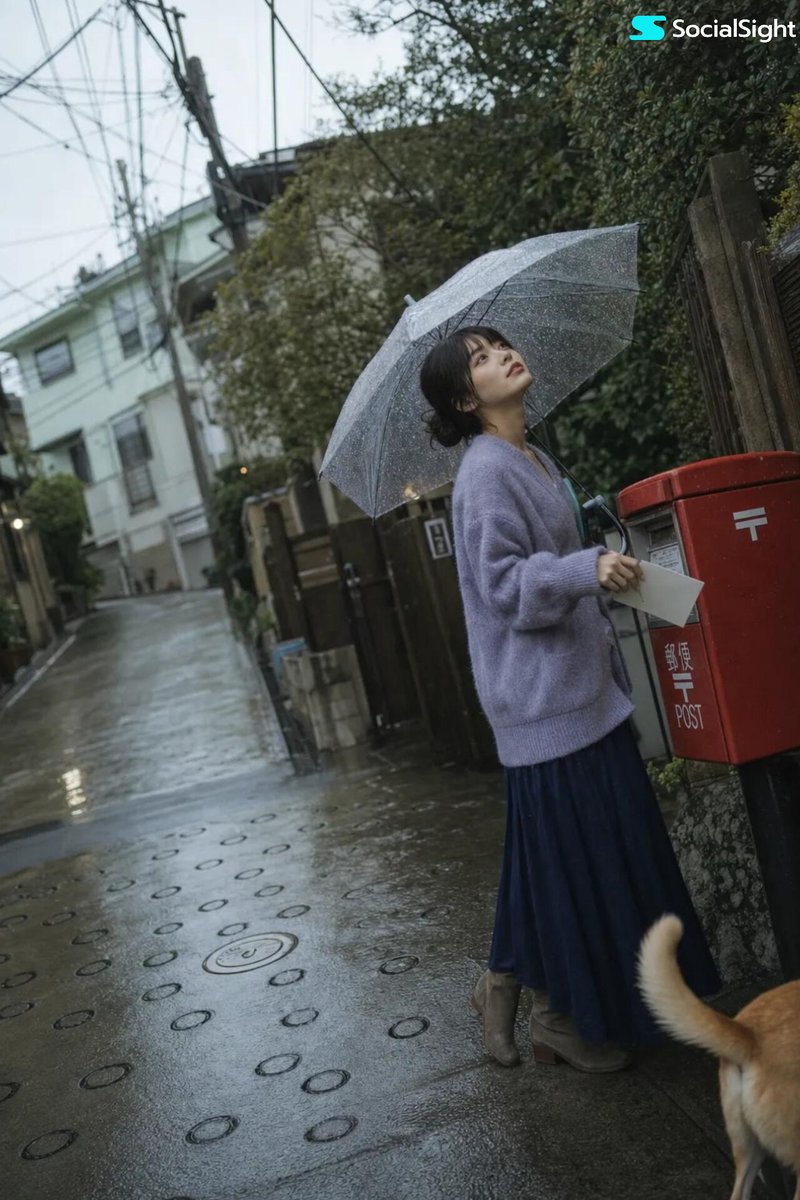 一张电影感、怀旧风格的生活摄影照片，拍摄于日本雨后湿漉漉的住宅街道。一名留着利落齐下巴短波波头的年轻日本女性站在一辆经典的妈妈骑（mamachari）自行车旁，一只手轻轻搭在车把上。她撑着一把...