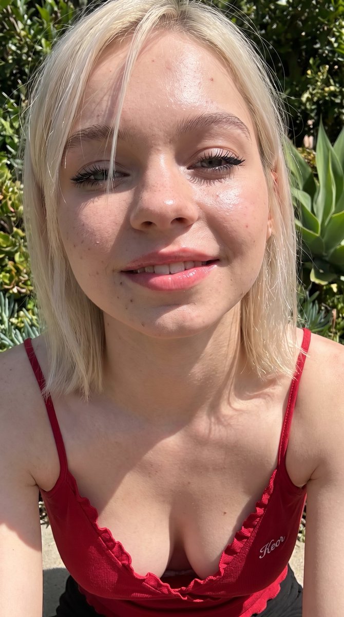 Emma Myers 真人版般的照片级超特写自拍，白皙至中等偏浅肤色，保留自然肌肤纹理，可见毛孔，被阳光直射后在额头、鼻尖、脸颊和下巴产生强烈高光的油亮水光肌，铂金色直发齐肩长，侧分刘海与散落...
