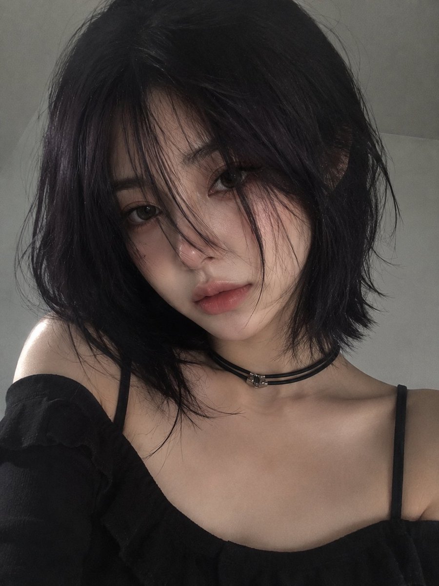柔和极简风格的人像肖像：一位年轻女性，留着光滑的深紫黑色波波头与细长的碎刘海，刘海部分遮住一只眼睛，她轻轻地将一朵白色雏菊花举在唇前。苍白瓷器般的肌肤上带着淡淡自然的红晕，深灰绿色双眸，神情平...