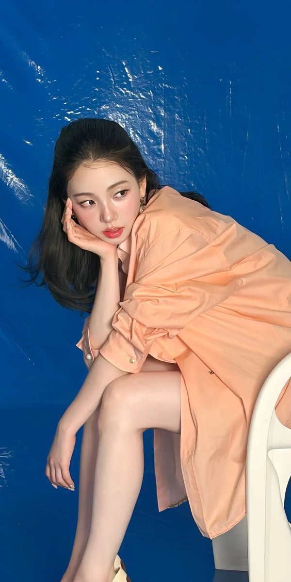 高端时尚编辑大片美妆广告,画面中是一位优雅的东亚女性模特,拥有无瑕瓷器般肌肤、水润自然的双唇、柔和的蜜桃色腮红以及细腻的微翘眼线。利落短款黑色波波头发型,搭配轻盈碎刘海。她身穿一件半透明金属质...