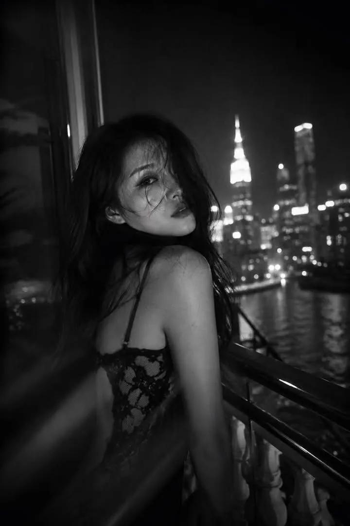 创作永恒的黑白电影感人像，运用戏剧性光效、胶片颗粒、情感氛围以及标志性的编辑美学。黑白光影色彩，胶片质感，人物质感，独特视角，一位[美丽的人物]，搭配[特定的发型或时尚造型]，置身于[地点类型...