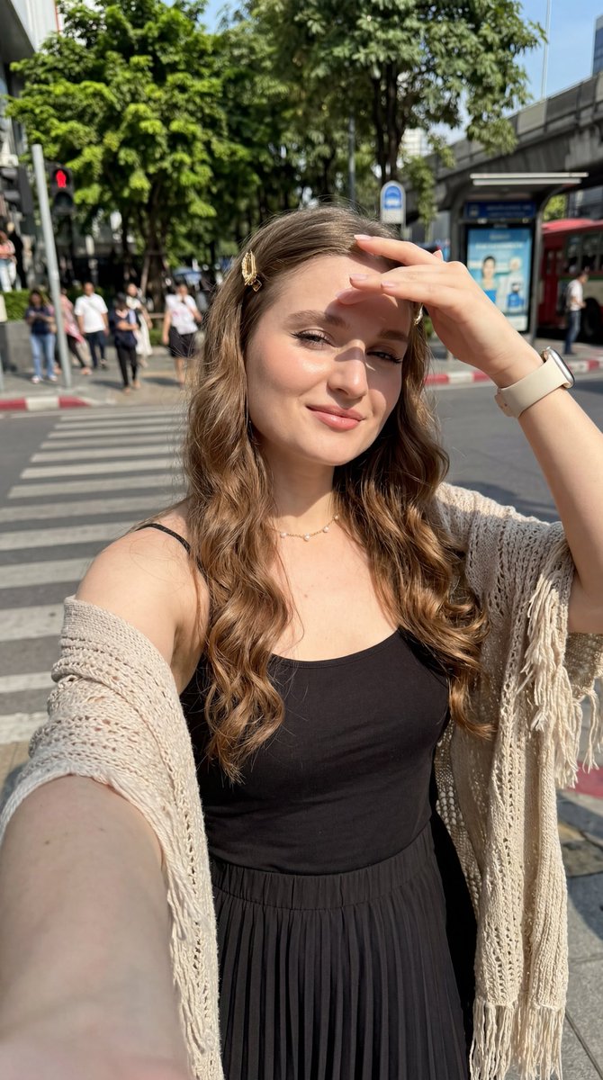超写实 8K 近距离自拍,年轻欧洲女性,略仰拍视角,手臂伸展握着手机,明亮晴朗的白天,直射的强烈阳光,锐利的面部阴影,艺术化的高对比度光影,充满活力的强烈氛围,轻微温柔的微笑,白皙粉色调发光光...