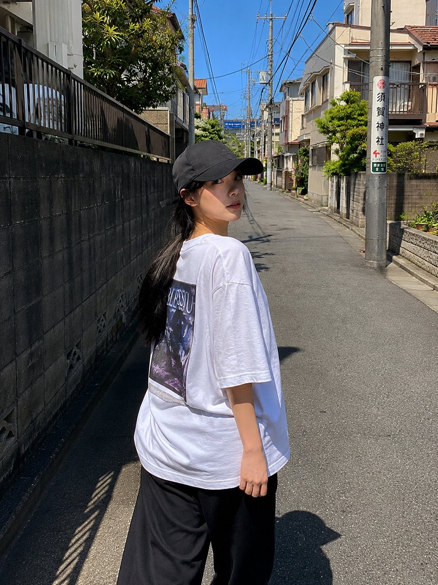 一位超美的年轻日本女性，拥有无瑕陶瓷般肌肤、自然红润的脸颊、光泽粉嫩的嘴唇、大而闪亮的杏仁眼，还有乌黑丝滑长发在风中肆意飞扬。她身着醒目的 oversized 亮红色校队夹克，内搭修身白色短款...