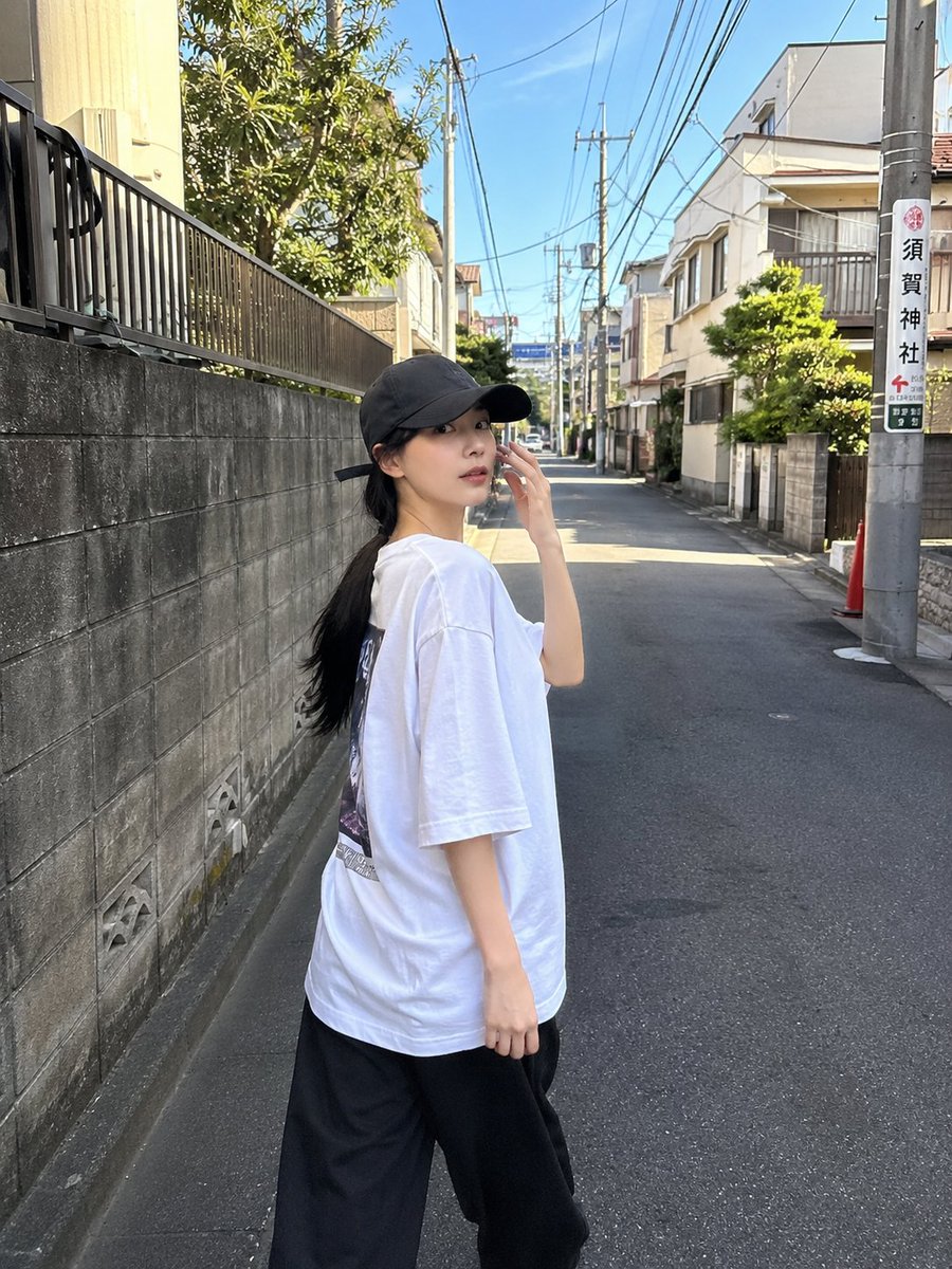 一位超美的年轻日本女性，拥有无瑕陶瓷般肌肤、自然红润的脸颊、光泽粉嫩的嘴唇、大而闪亮的杏仁眼，还有乌黑丝滑长发在风中肆意飞扬。她身着醒目的 oversized 亮红色校队夹克，内搭修身白色短款...
