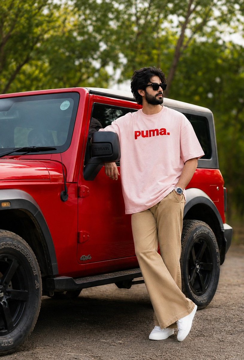 24岁 创作 卡其色 重磅 全身 宽松 粉色 T恤，带有红色文字 puma。喇叭裤。白色运动鞋。手表戴在左手。略微凌乱的深色头发 黑色太阳镜。在红色 THAR（越野车）旁摆出随机时尚的姿势。背...