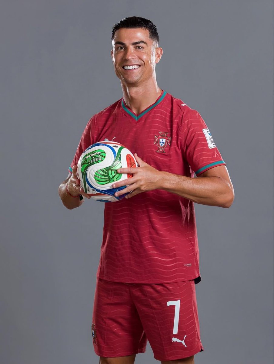超写实克里斯蒂亚诺·罗纳尔多（Cristiano Ronaldo）肖像，身穿葡萄牙国家队球衣，7 号球衣，英雄般矗立在一座巨型足球场的中央，表情坚毅，冠军气场，头上方漂浮着一顶金色皇冠，身体周...