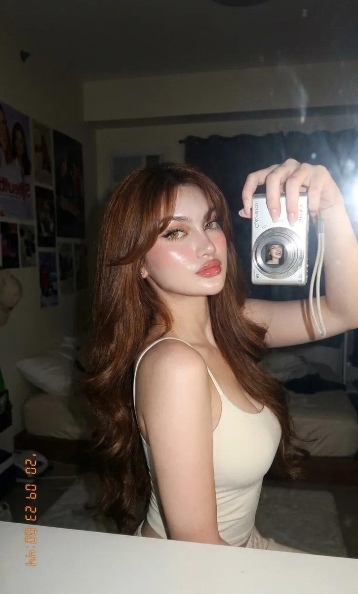 超写实特写美女肖像，一位令人惊艳的年轻女性，采用 iPhone / 数码相机美感的直接机顶闪光灯拍摄于昏暗的室内环境。华丽自然的美女镜头，带柔和镜头光晕、微妙闪光绽放、皮肤光泽反射、梦幻女性气...