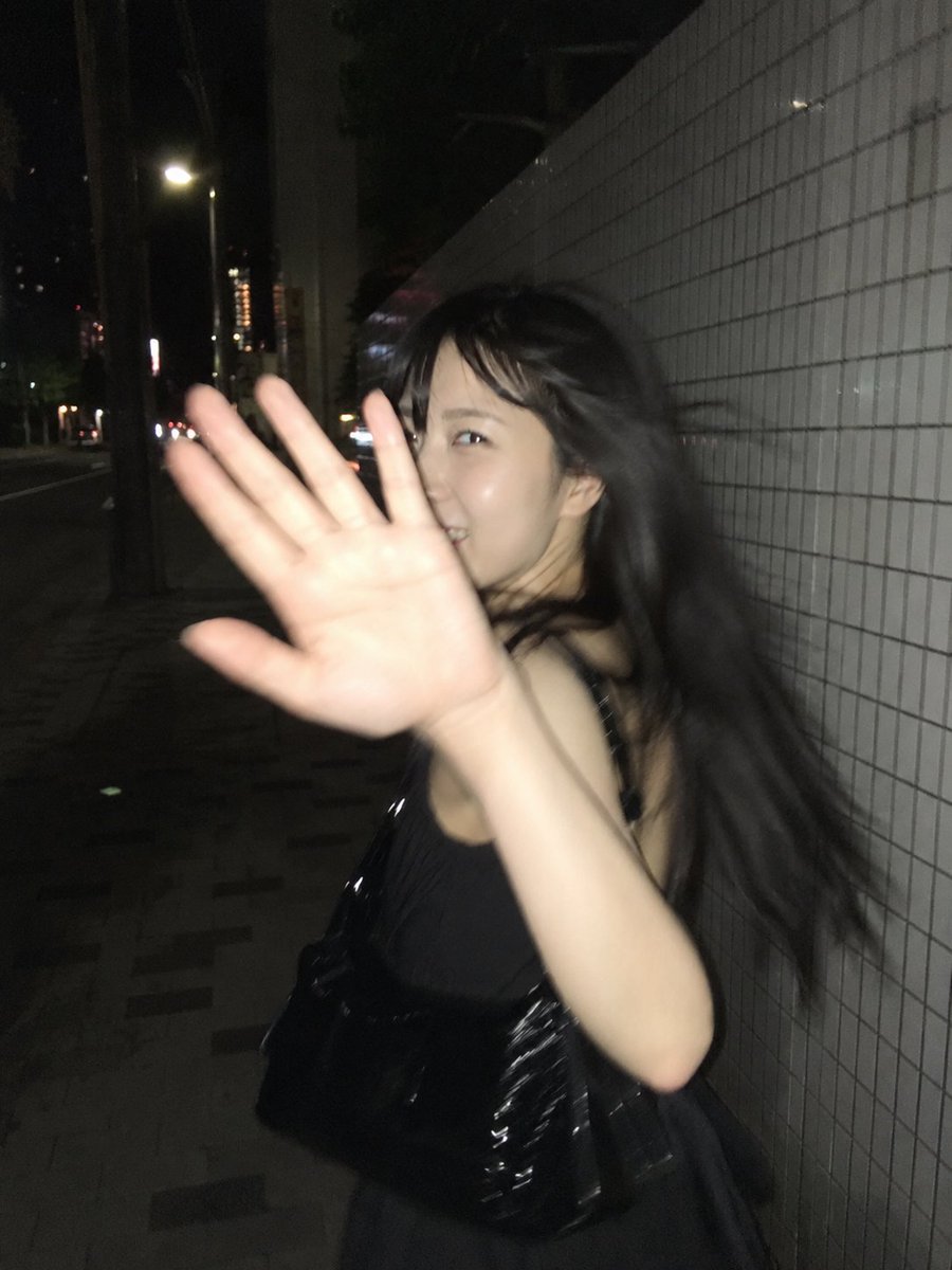 超写实的抓拍式智能手机闪光灯照片，竖向构图，3:4 比例。一位年轻的东亚女性，夜晚在一段安静的城市街道上快步前行，街边是一面长长的白色瓷砖墙。以一种自发的狗仔队风格瞬间捕捉——她突然注意到镜头...