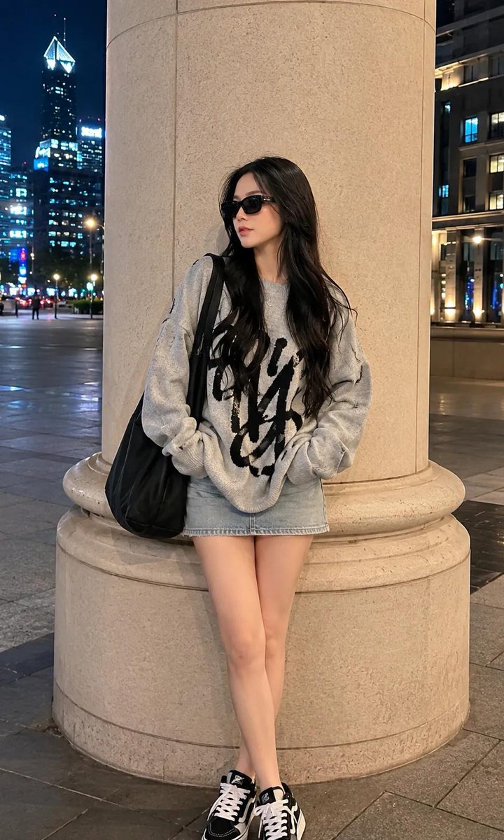 超写实全身时尚肖像：一位美丽的年轻女性，夜晚站立在豪华都市商业区一根高大的米色建筑立柱旁，神态轻松随意。面部轮廓柔和女性化，肌肤白皙无瑕，身材比例优雅，气场自信甜美，佩戴黑色矩形墨镜，目光微微...