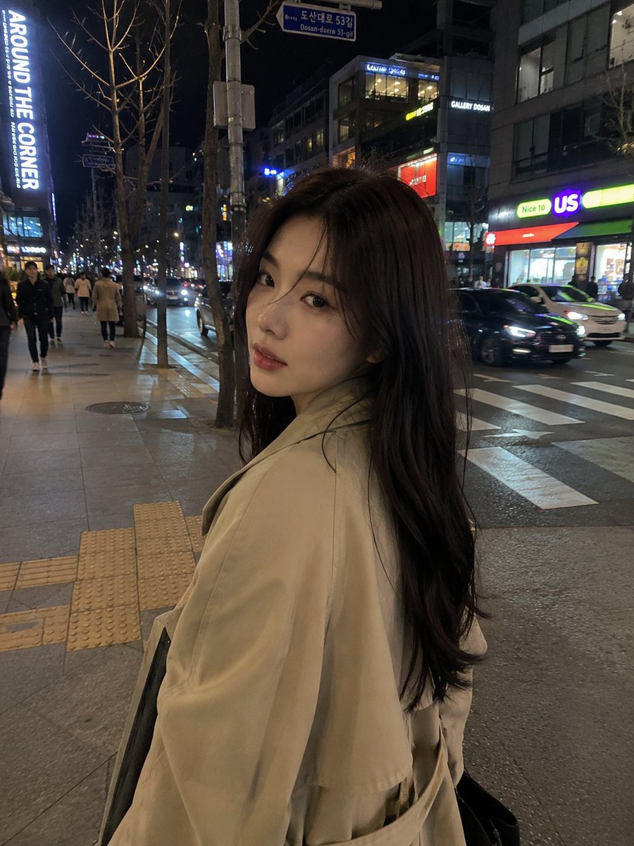 超写实的随拍 iPhone 街头照片：一位美丽的年轻韩国女孩，夜晚穿过霓虹灯闪烁的首尔街道，从侧视角抓拍，电影感的都市氛围，自然的行走姿态，黑色长发随风飘动，身穿米色超大号风衣，休闲韩式穿搭，...