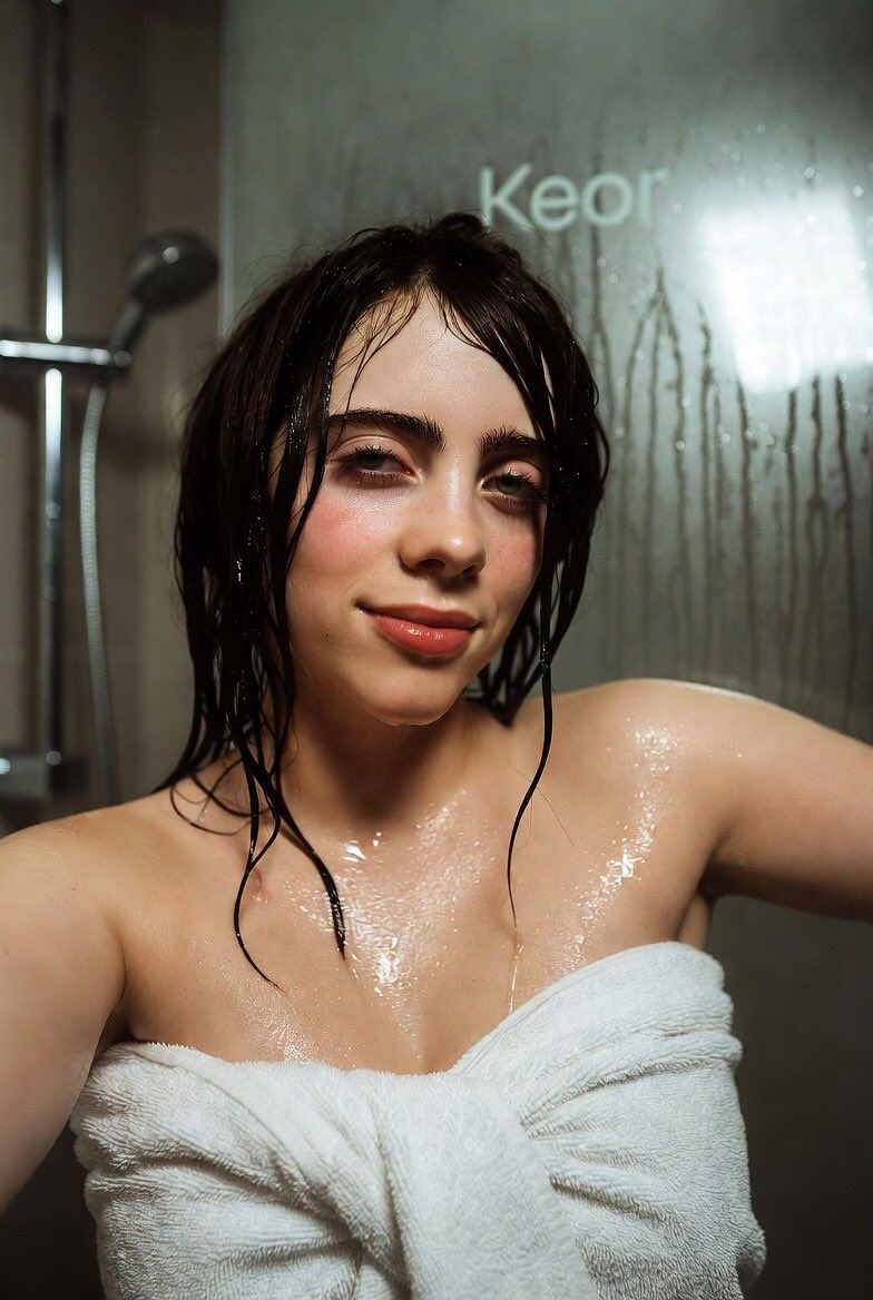 Billie Eilish, 柔和的椭圆脸型，颧骨线条细腻自然，嘴唇天生丰润，眼睛略呈内双，包含真实皮肤毛孔/细小汗毛/痣/雀斑，面部解剖结构年轻且具有真实的不对称感, 大而富有表现力的蓝灰色...
