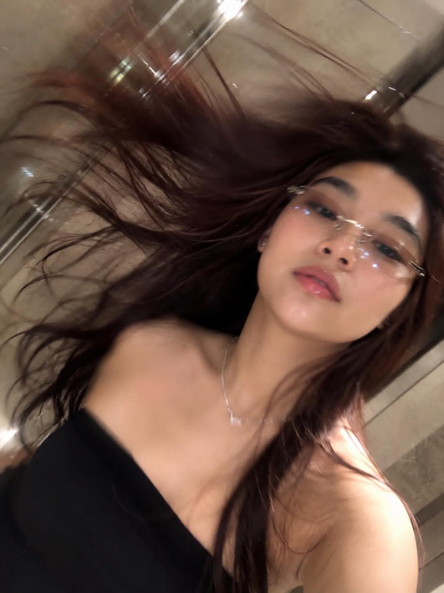 夜晚在奢华的米色大理石浴室中，一位美丽年轻女性拍摄的超写实镜面自拍，使用极为强劲的 iPhone 直闪闪光灯直接打向镜子。闪光在镜面中产生强烈的白色闪光爆炸效果，伴随厚重光晕（bloom）、锐...