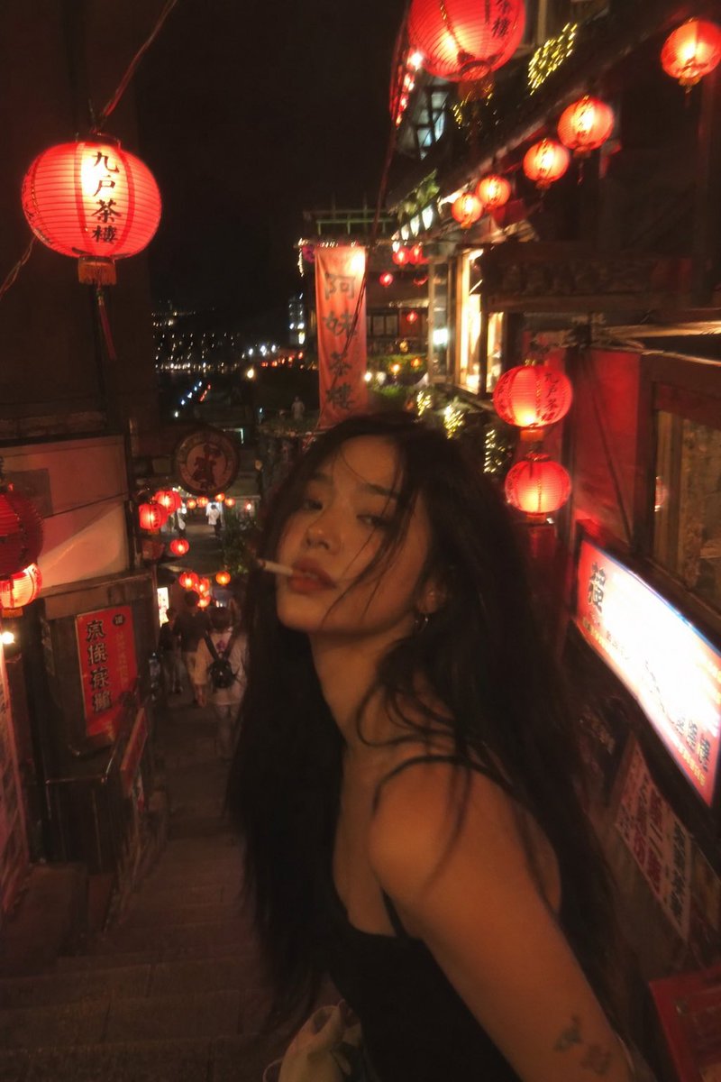 失焦抓拍风格的照片：一位亚洲时装模特站在夜晚的台湾老街中央，四周环绕着发光的红色灯笼。香烟美学氛围，暖色调，Pinterest 风格感觉。 #AIart #GPTImage2