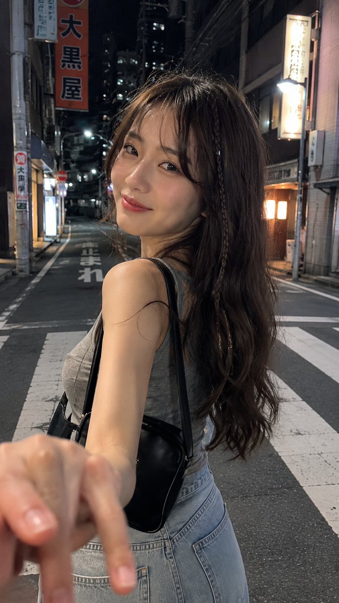 一张电影感十足的夜间街头抓拍人像，拍摄于日本街头，使用 iPhone 拍摄。一名年轻女子，长长的深棕色波浪卷发中编有一缕细辫，淡妆，嘴角带着若有...