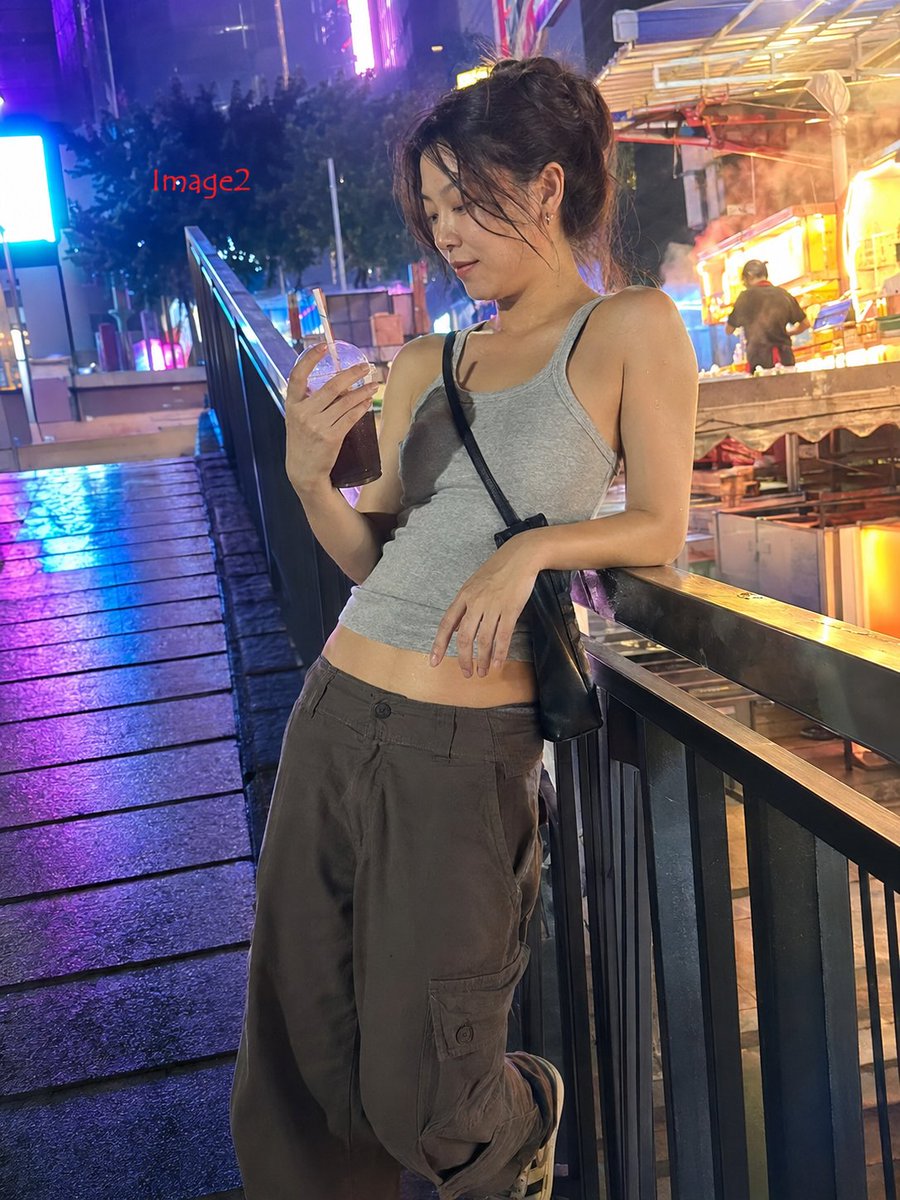 3:4，iPhone 17 35mm 镜头抓拍的真实生活照片。 主体：25 岁以上的中国女性，身材修长健美，自然的面部特征，穿着紧身灰色背心，因...