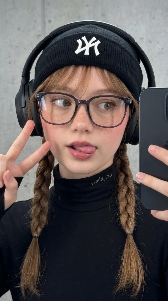 不要改变她的脸部。一张酷感都市街头风的时尚年轻女性特写自拍肖像。她身穿全黑装束,搭配修身高领上衣、带白色logo的黑色毛线帽、夸张的黑色头戴式耳机,以及大框透明黑框眼镜。她的头发编成两条整齐的...