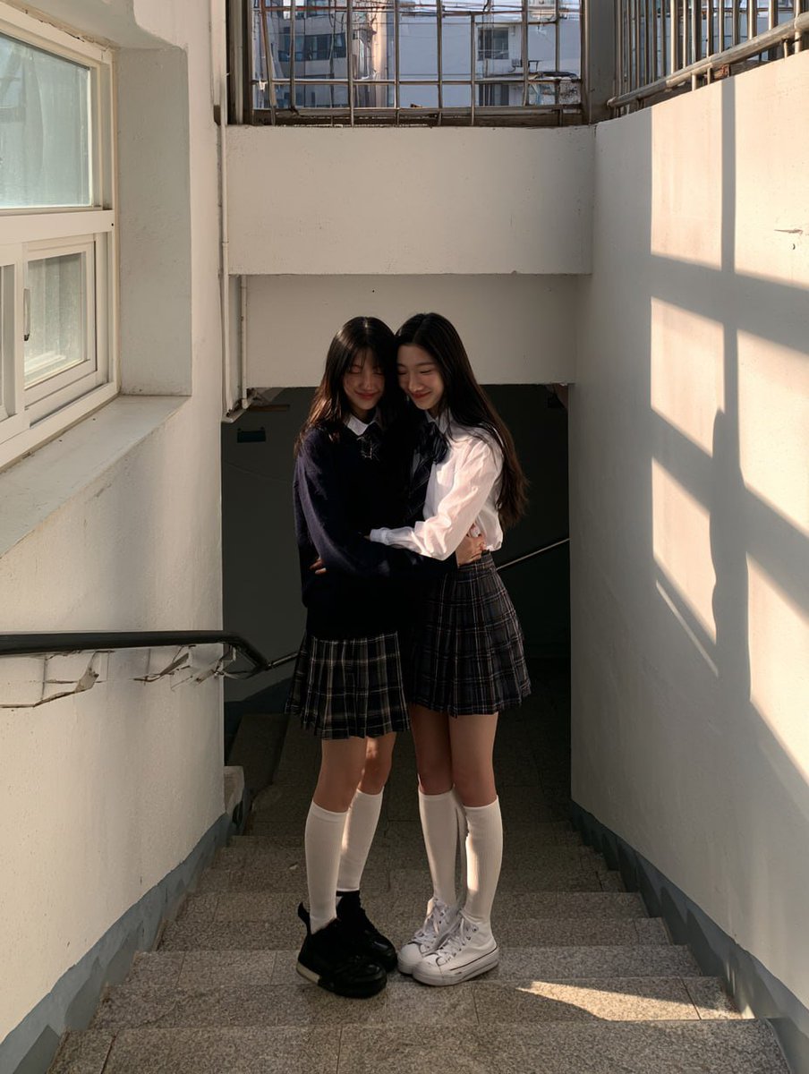 Nano banana pro 宣传与电影感提示 ⤵️ 2名女高中生站在学校楼梯上，温暖地相互拥抱，带着含蓄幸福的微笑，彼此对视而非看镜头，没有察觉被拍摄，抓拍瞬间，真实的韩国学校楼梯间，柔和...
