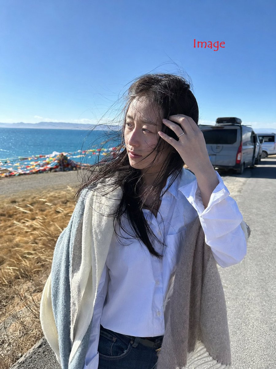 3:4，iPhone 17 后置摄像头搭配 26mm 广角镜头拍摄的写实抓拍照片。 主体：28 岁以上身材纤细的中国女性，身着宽松白衬衫、深蓝色牛仔裤、短靴，肩上披着柔软的披肩，手指上戴着简约...