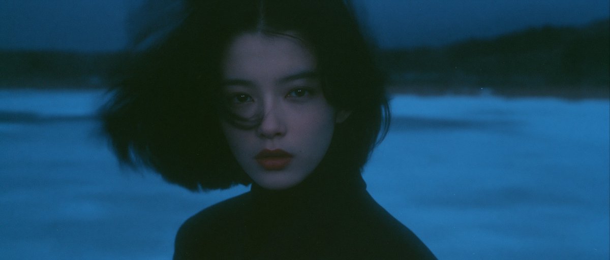 以电影《情书》的风格为基调，呈现岩井俊二的影像美学。一位身着深色冬季校服的中国女孩站在冰封的湖面上。整体采用清冷的青蓝色调，画面洁净极简，笼罩在...