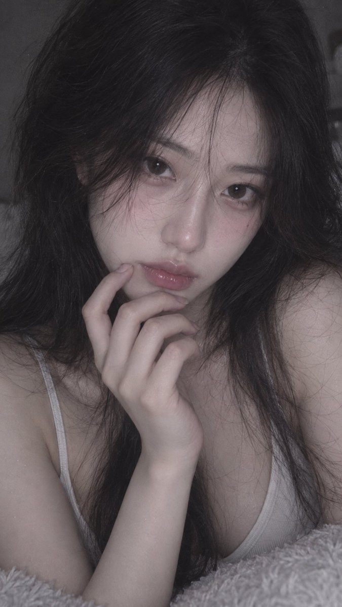 📱 iPhone 前置摄像头随手抓拍，9:16；18–22 岁、明确成年的漂亮东亚女性，约 1.75 米，精致五官，冷白通透肌肤，高挑纤细模特身材，胸部视觉约自然 E 罩杯。深色柔顺蓬松大波浪...