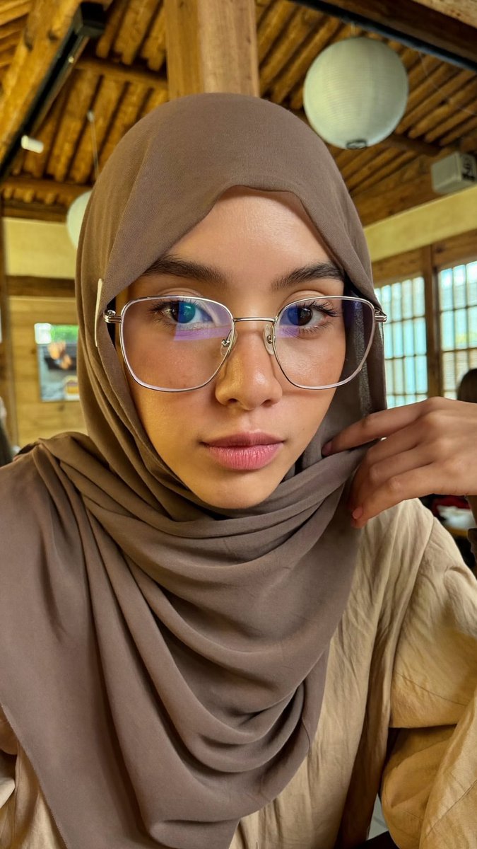 [Higgsfield Soul 2.0 提示词] ar 9:16 2K 一位年轻东亚女性的特写自拍照,她戴着一条灰褐色/柔和棕色的雪纺头巾,轻柔地披在面部和肩部周围,完全遮住头发。她肤色白皙...