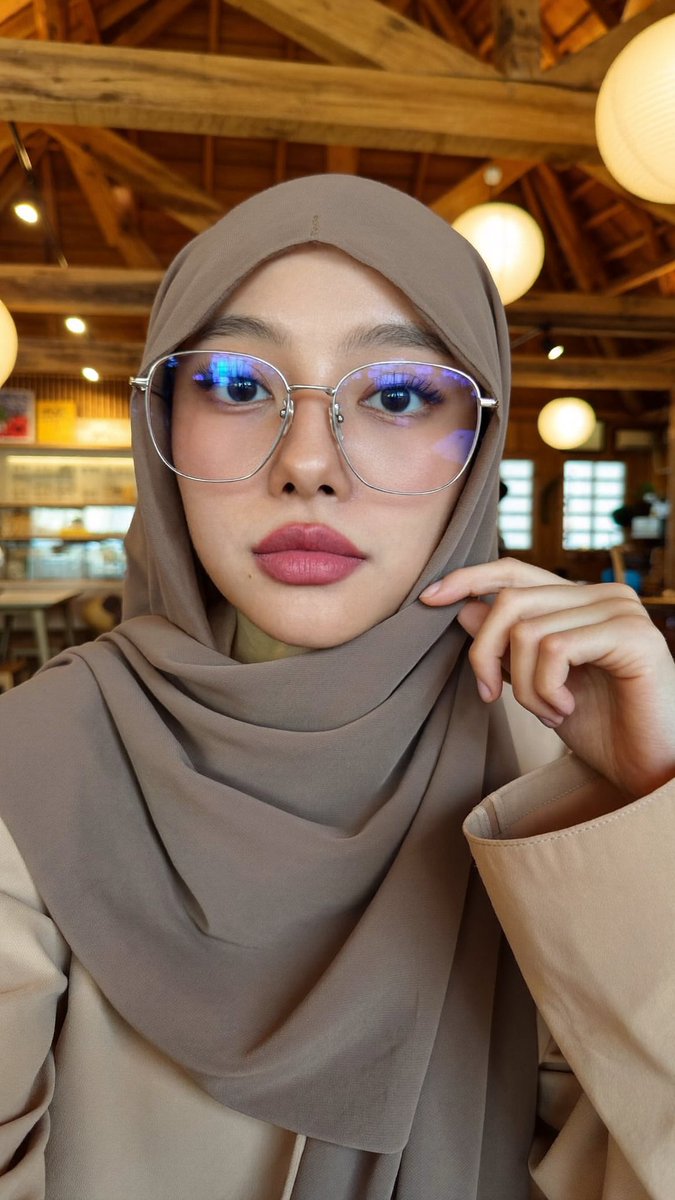 [Higgsfield Soul 2.0 提示词] ar 9:16 2K 一位年轻东亚女性的特写自拍照,她戴着一条灰褐色/柔和棕色的雪纺头巾,轻柔地披在面部和肩部周围,完全遮住头发。她肤色白皙...